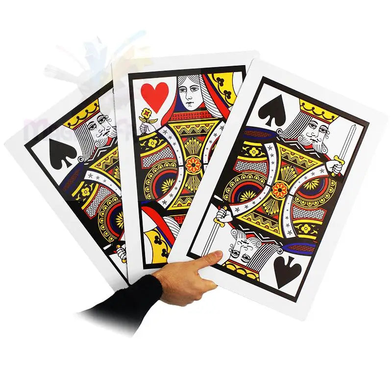 Drei übergroße Spielkarten, eine Herz-Dame und zwei Pik-Könige, werden von einer Hand gehalten.
