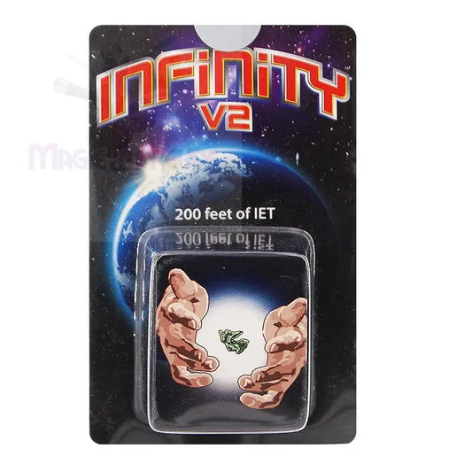 Ein verpacktes Spielzeug oder Sammlerstück mit zwei Händen, die sich nach einer kleinen grünen Figur strecken, mit dem Aufdruck ’INFINITY v2’’ und ’200 feet of IET’ auf der Verpackung.
