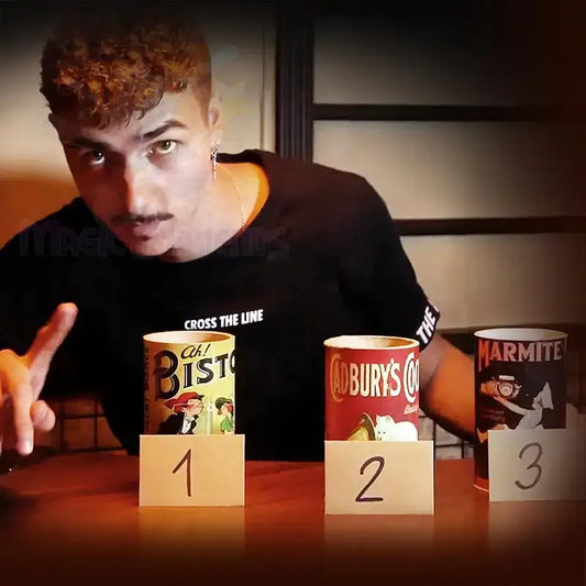 Magier zeigt Zaubertrick mit drei nummerierten Bechern auf Holztisch