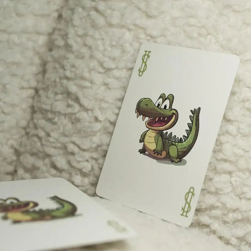 Spielkarte mit fröhlichem Krokodil-Comicmotiv für Zaubertricks, Nahaufnahme auf hellem Untergrund
