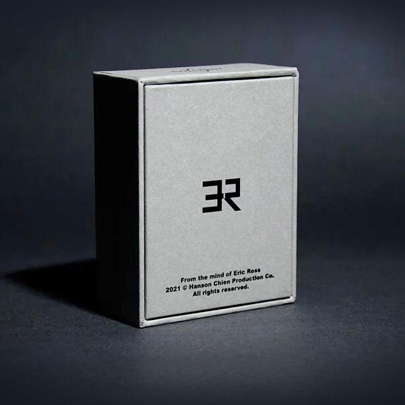 Graue Zaubertrick-Box mit schwarzem Logo und Aufschrift, Produktfotografie auf dunklem Hintergrund