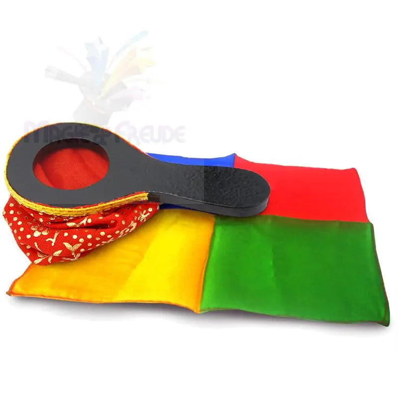 Ein schwarzes Paddel mit einem kreisförmigen Ausschnitt, der bunte Stoffquadrate und ein rot gemustertes Tuch zeigt.