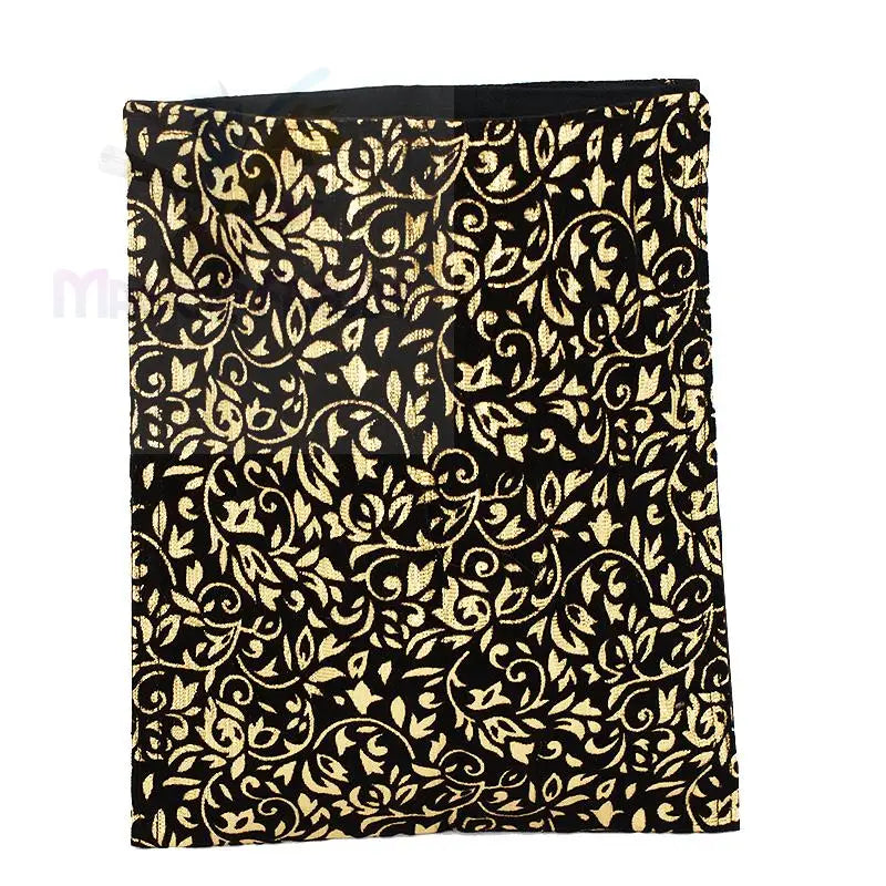 Ein schwarzer Stoff mit einem verschlungenen Muster aus Blattgold und Ranken.