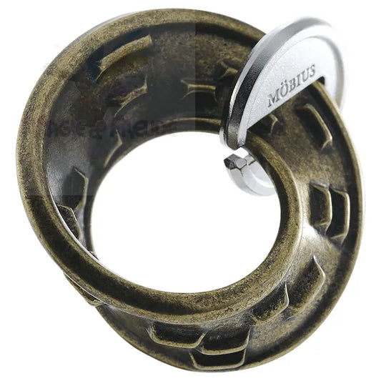Ein antikes bronzefarbenes Metallpuzzle mit einem silberfarbenen ’Möbius’-Emblem.