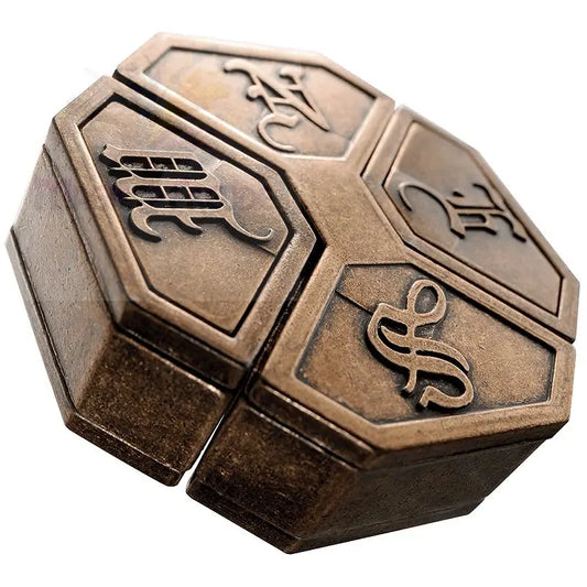 Eine bronzefarbene Metallpuzzlebox mit verschnörkelten Symbolen auf den sechseckigen Flächen.