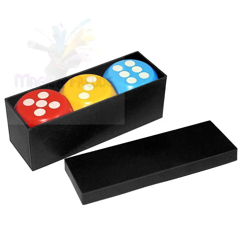 Drei bunte Würfel in einer schwarzen, rechteckigen Schachtel mit Deckel.