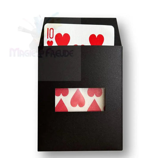Eine schwarze Kartenschachtel, die durch eine rechteckige Aussparung einen Teil einer roten Spielkarte mit Herz zeigt.