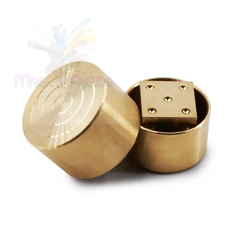 Zwei Metallbehälter aus Messing, einer mit konzentrischen Kreisen auf dem Deckel, der andere mit einem quadratischen Messingeinsatz mit fünf vertieften Punkten.