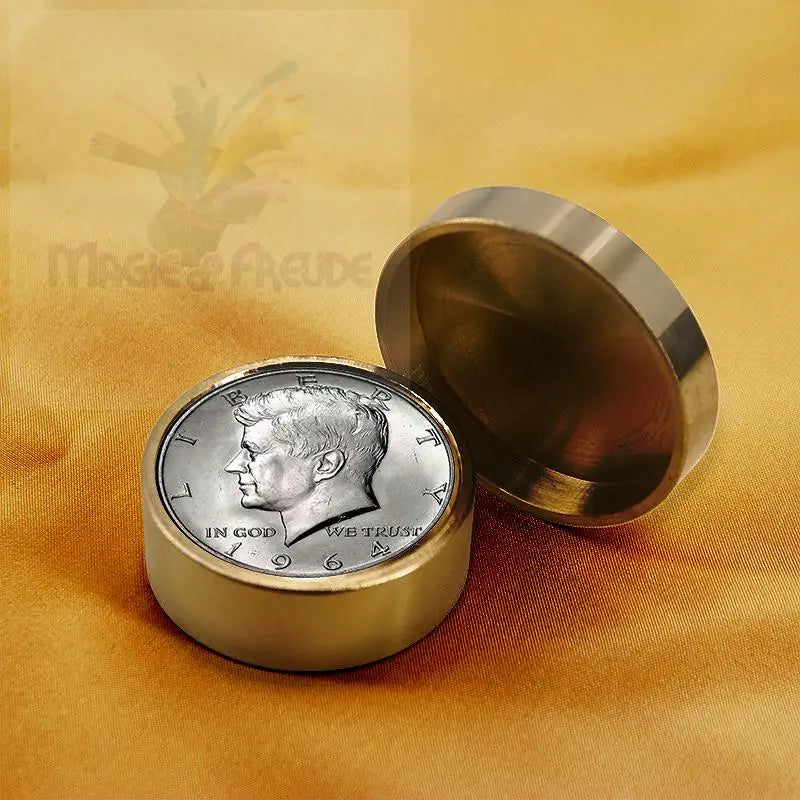 Eine silberne Kennedy-Halbdollarmünze, eingefasst in einen goldfarbenen Ring, mit passendem Metalldeckel.