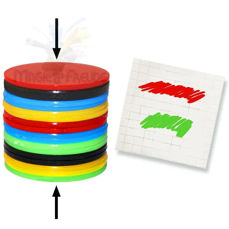 Ein Stapel bunter, runder Magnetplättchen mit einem Papierblock mit roten und grünen Markierungen.