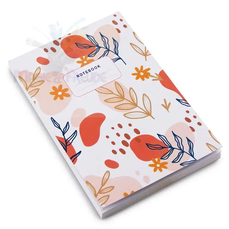 Ein Notizbuch mit weißem Einband, der mit einem Muster aus orangefarbenen, rosa und blauen botanischen Elementen verziert ist.