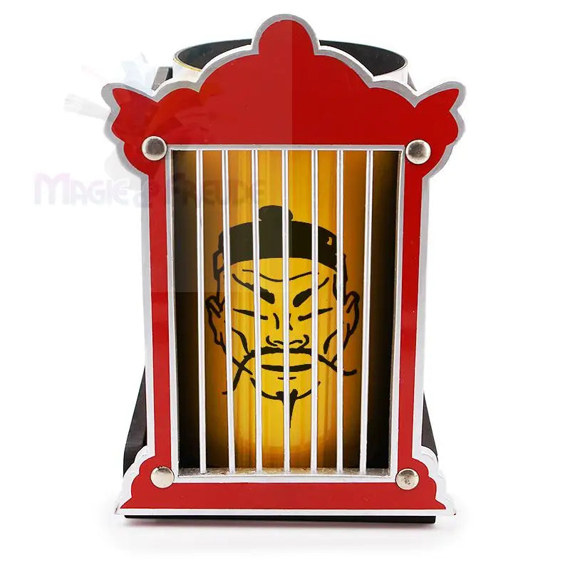 Eine rote und silberne käfigartige Neuheit mit einem gelben Innenzylinder, auf dem ein stilisiertes asiatisches Gesicht abgebildet ist.