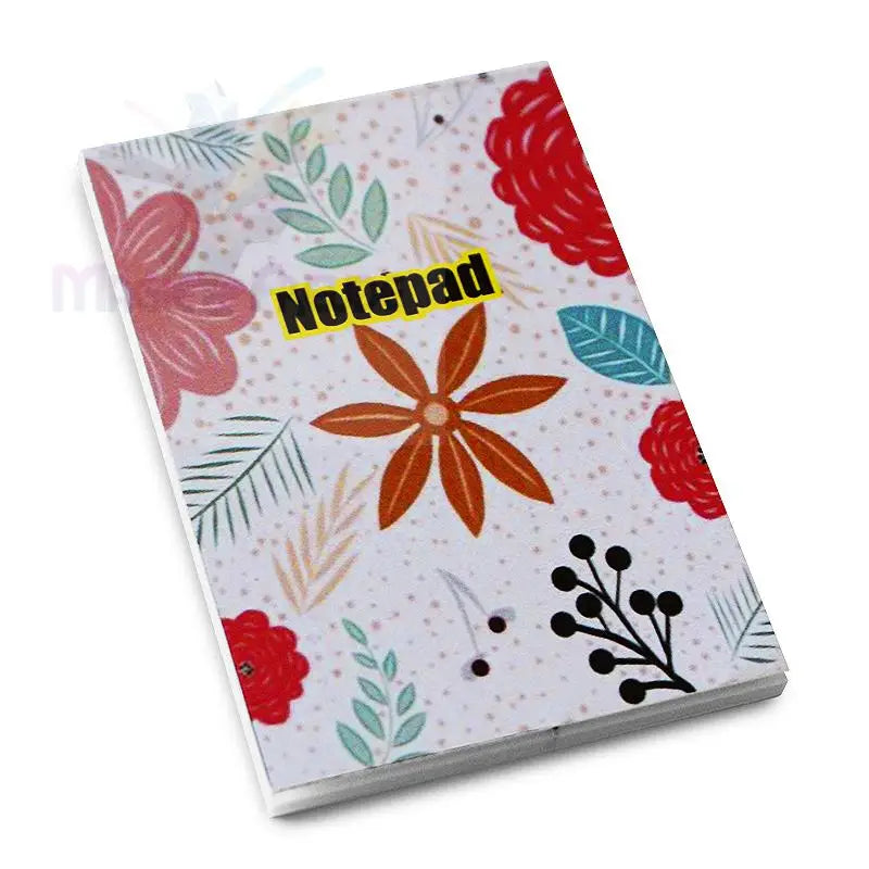 Ein geblümter Notizblock mit einem gelben Etikett ’Notepad’.