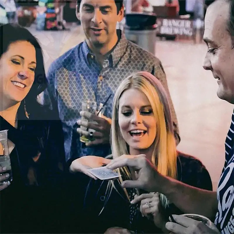 Eine Gruppe von vier Erwachsenen, die einen Zaubertrick genießen.