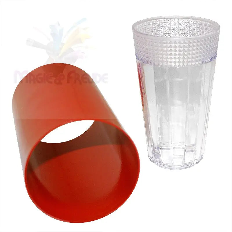 Ein klares Trinkglas mit einem strukturierten Deckel und einem roten zylindrischen Objekt.