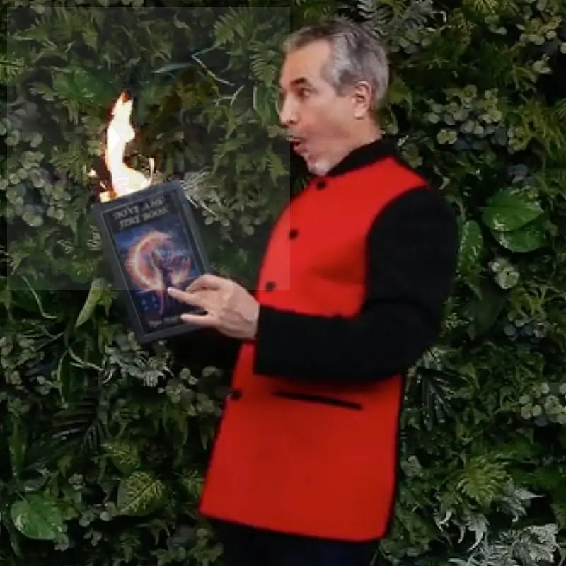 Mann in roter Weste hält ein brennendes Buch.