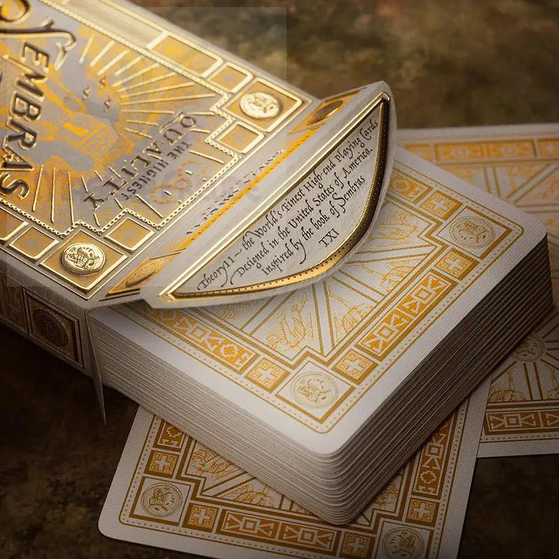 Ein offenes Spielkartenset mit verschnörkelten goldenen und weißen Motiven.