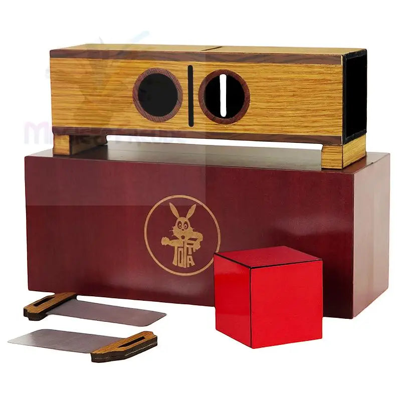 Zaubertrickbox aus Holz mit einem roten Würfel und zwei Metallklingen.