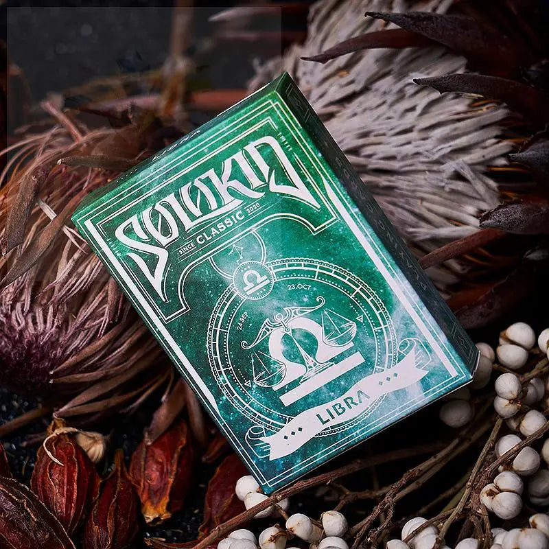 Grünes Spielkartenset zum Thema Tierkreiszeichen mit Waage-Motiv.