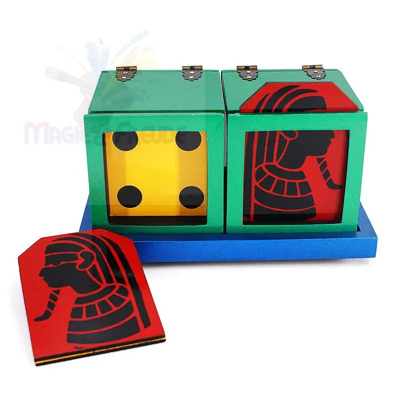Ein Zaubertrickset mit zwei grünen Schachteln auf blauem Grund, von denen eine ein Würfelgesicht und die andere die Silhouette eines ägyptischen Pharaos zeigt, mit einer separaten Karte zum Thema Pharao.