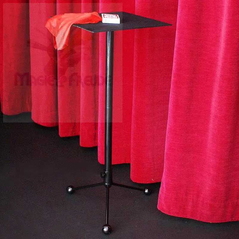 Schwarzer, zusammenklappbarer Zauberertisch mit quadratischer Platte, geeignet für die Aufbewahrung von Requisiten während einer Vorführung.