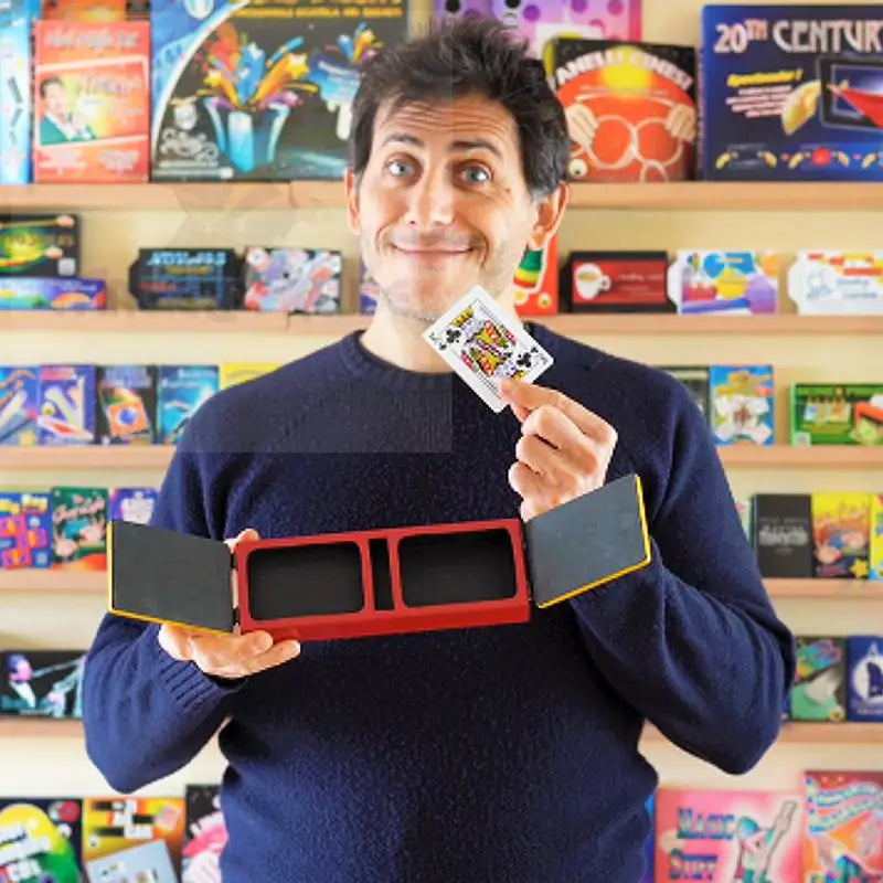 Ein Mann hält eine Spielkarte und einen offenen rot-schwarzen Zauberkasten.