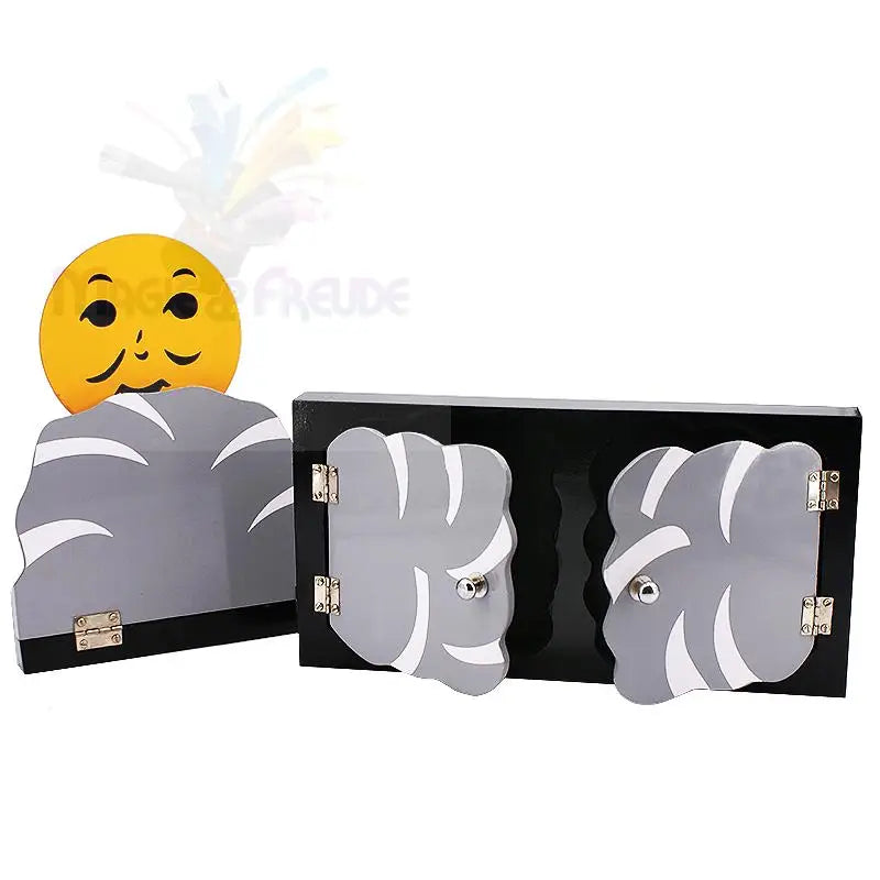 Ein schwarzes Zauberrequisit aus Holz mit zwei Flügeltüren und einem separaten, kleineren Teil mit einem gelben lächelnden Gesicht.