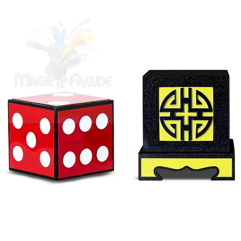 Ein roter Würfel mit weißen Punkten und einem schwarz-gelben quadratischen Ornament.
