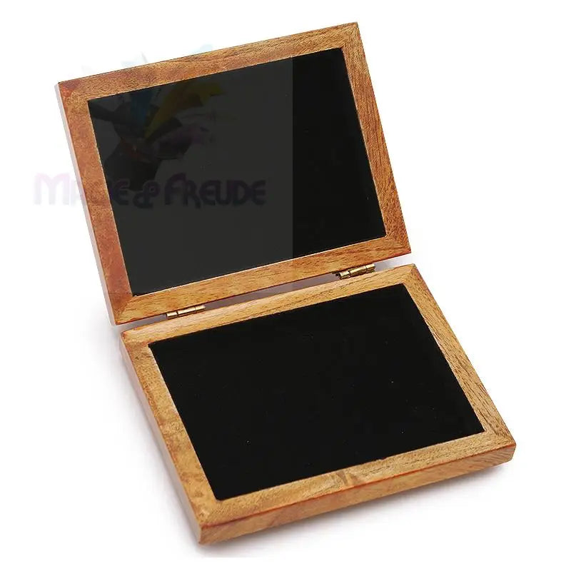 Ein offenes Holzkästchen mit einem Innenleben aus schwarzem Samt.