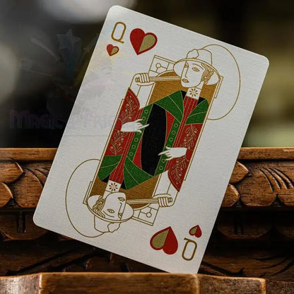 Spielkarte Herz Dame mit rot-grün-goldenem, verzierten Design auf Holzuntergrund
