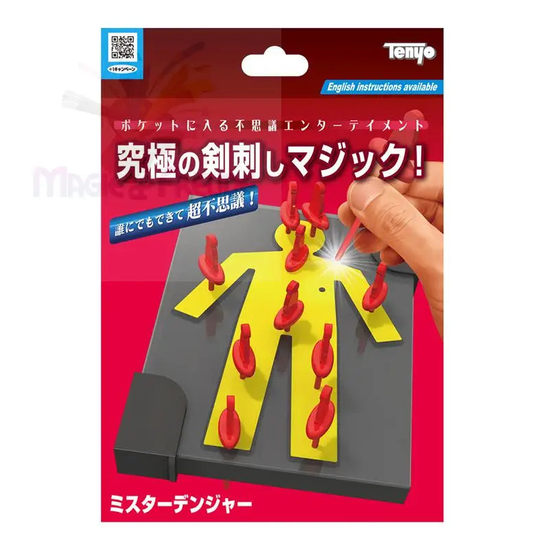 Ein Zaubertrickspielzeug mit einer gelben menschlichen Figur auf einem grauen Brett, die scheinbar von roten Stecknadeln durchbohrt wird, und einer Hand, die eine rote Stecknadel hält, was eine ’Stecknadel durch den Körper’-Täuschung suggeriert.