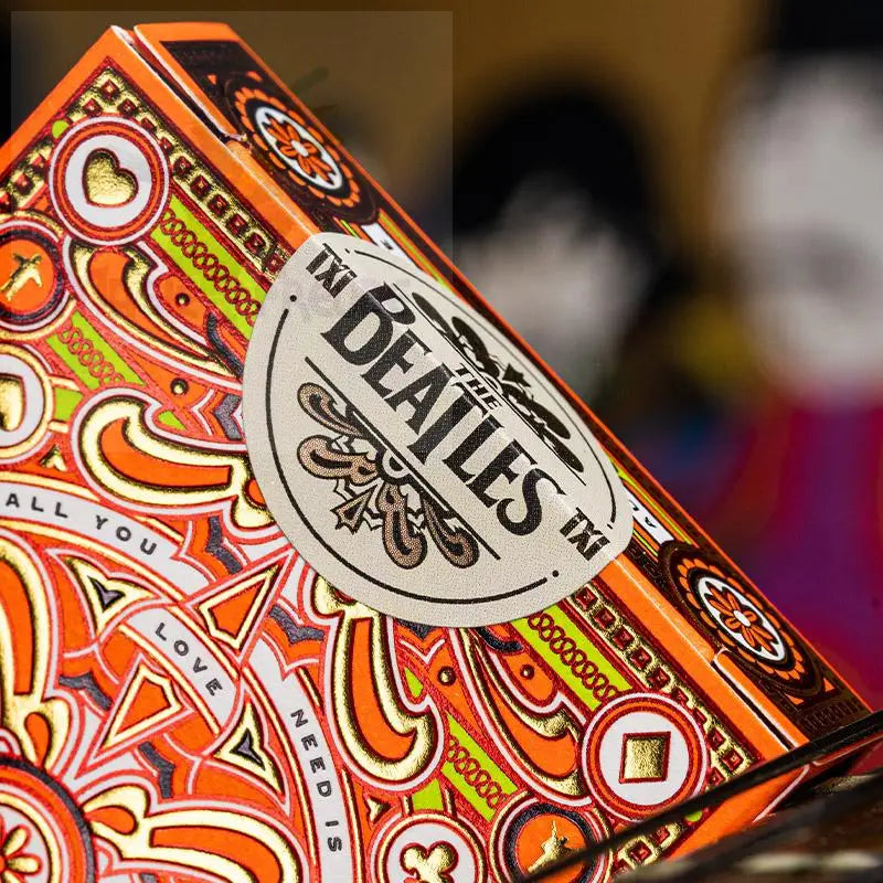 Verschnörkelte orange-goldene Spielkartenbox im Beatles-Stil.
