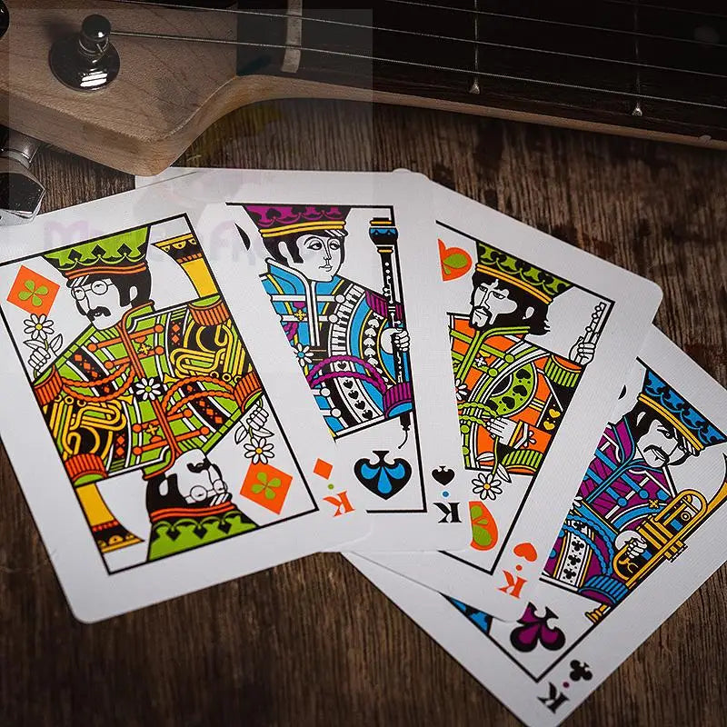 Ein Fan von vier bunten Spielkarten mit stilisierten Illustrationen von The Beatles.