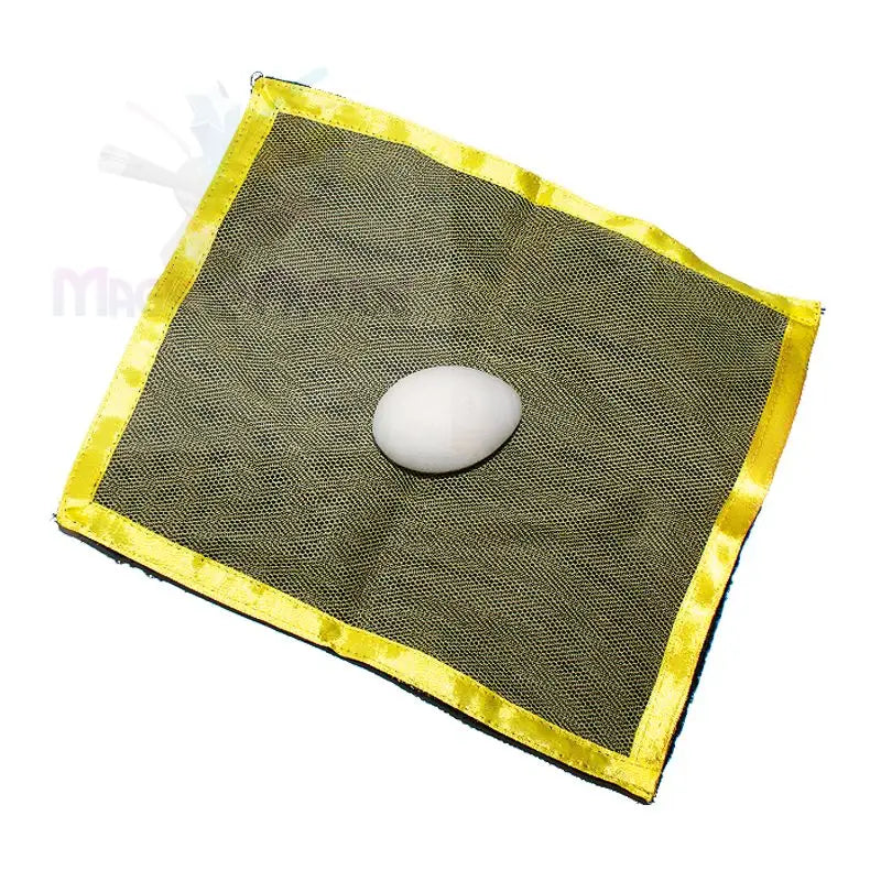 Ein einzelnes weißes Ei, das auf einem quadratischen Stück dunklen Netzstoffs mit gelbem Rand ruht.