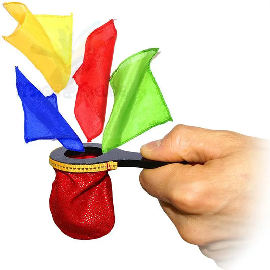 Eine Hand, die ein schwarzes Zauberrequisit mit einer roten Tasche und bunten Seidentüchern in der Hand hält.
