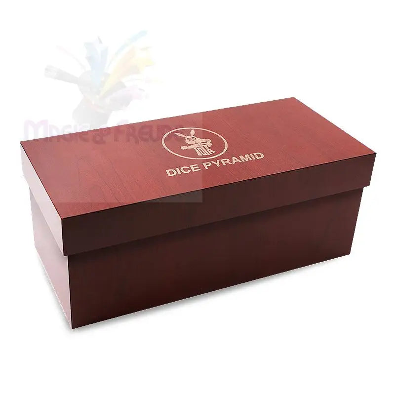 Rechteckige, tiefrote Holzkiste mit hellrotem Deckel, auf dem ein kreisförmiges Logo und die Aufschrift ’DICE PYRAMID’ eingeprägt sind.